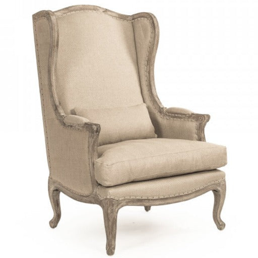 Sedia in lino - La nostra sedia presenta una classica silhouette a wingback in stile rustico con rivestimento naturale, gambe in rovere grigio sbiancato e schienale in juta con dettagli borchiati.