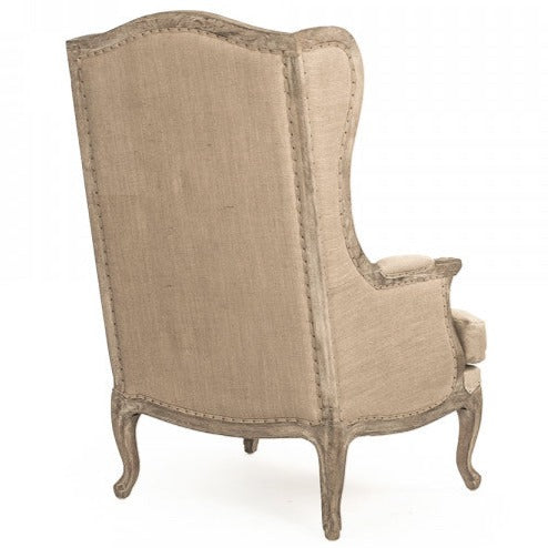 Sedia in lino - La nostra sedia presenta una classica silhouette a wingback in stile rustico con rivestimento naturale, gambe in rovere grigio sbiancato e schienale in juta con dettagli borchiati.