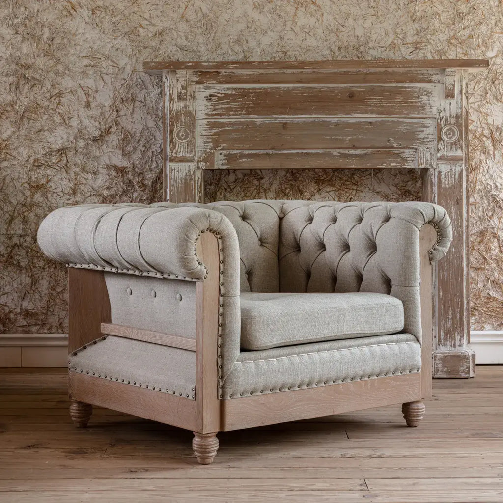 Poltrona Chesterfield - Aggiungendo un tocco di fascino rustico con un pizzico di raffinatezza, questa poltrona capitonné presenta un lino neutro lavato con eleganti braccioli arrotolati, capitonné a bottoni