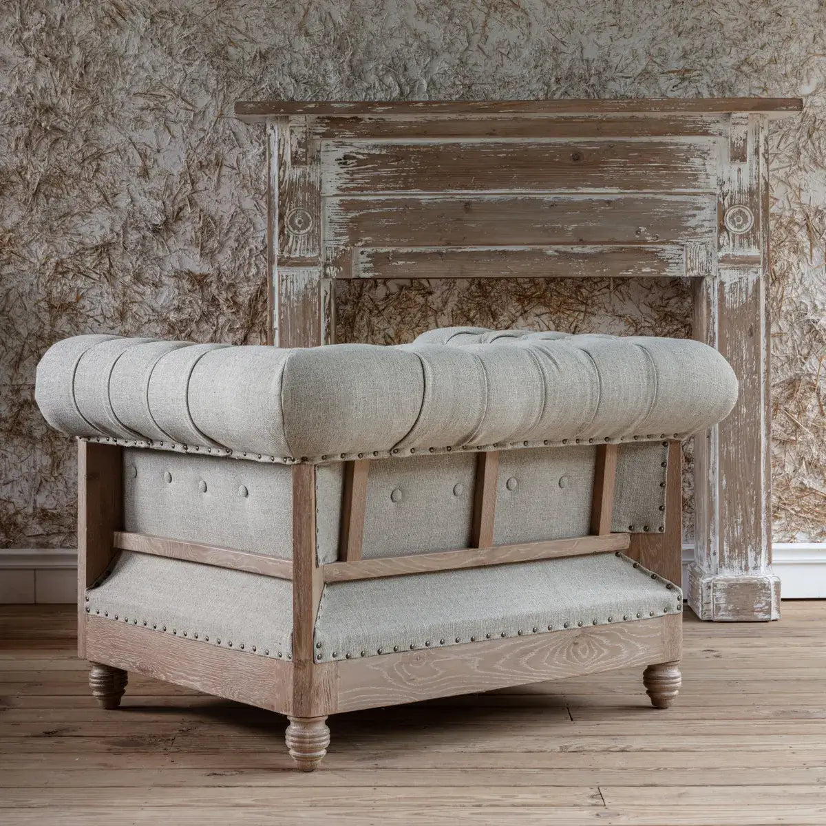 Poltrona Chesterfield - Aggiungendo un tocco di fascino rustico con un pizzico di raffinatezza, questa poltrona capitonné presenta un lino neutro lavato con eleganti braccioli arrotolati, capitonné a bottoni