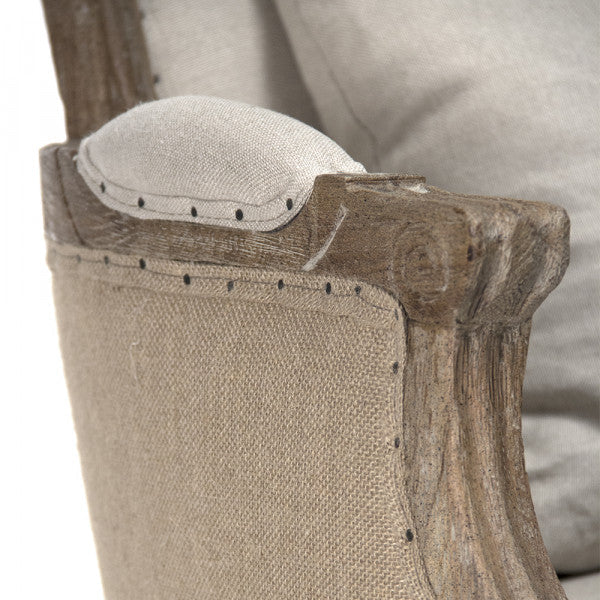 Poltrona Club - Il nostro modello presenta una silhouette a schienale alto in stile rustico, con rivestimento in lino naturale, struttura in rovere naturale e schienale in juta con dettagli borchiati.